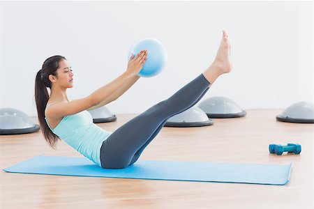 simsearch:400-04128723,k - Full length side view of a sporty young woman stretching body in fitness studio Photographie de stock - Aubaine LD & Abonnement, Code: 400-07334750