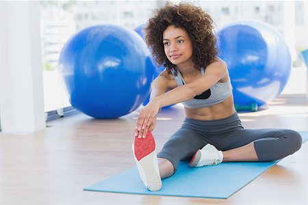 simsearch:400-04128723,k - Full length of a sporty young woman stretching hands to leg in fitness studio Photographie de stock - Aubaine LD & Abonnement, Code: 400-07335126