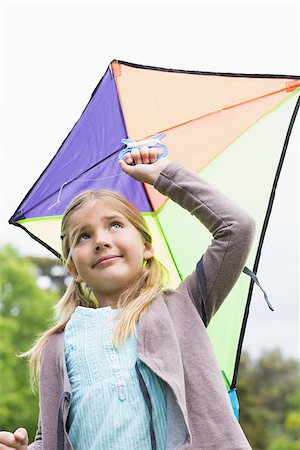 sky in kite alone pic - Low angle view of a cute young girl with a kite standing outdoors Stock Photo - Budget Royalty-Free & Subscription, Code: 400-07336845