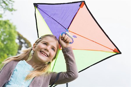 sky in kite alone pic - Low angle view of a cute young girl with a kite standing outdoors Stock Photo - Budget Royalty-Free & Subscription, Code: 400-07336846