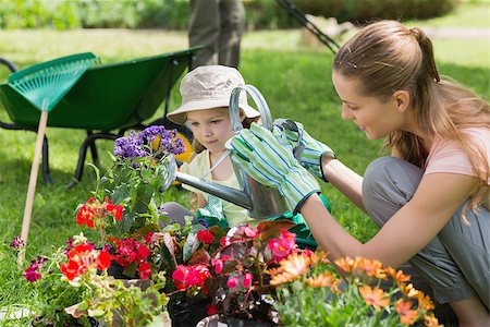Side view of a mother and daughter watering plants at the garden Stock Photo - Budget Royalty-Free & Subscription, Code: 400-07336951