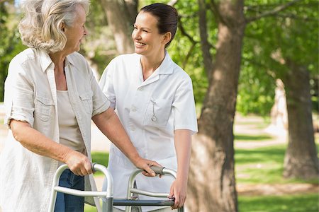 Smiling young female assisting mature woman with walker at the park Stock Photo - Budget Royalty-Free & Subscription, Code: 400-07337141