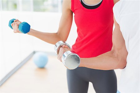 Closeup mid section of a sporty young couple with dumbbells in the gym Stock Photo - Budget Royalty-Free & Subscription, Code: 400-07333059