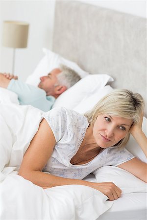 Closeup of a tensed woman lying besides man in bed at home Stock Photo - Budget Royalty-Free & Subscription, Code: 400-07333783