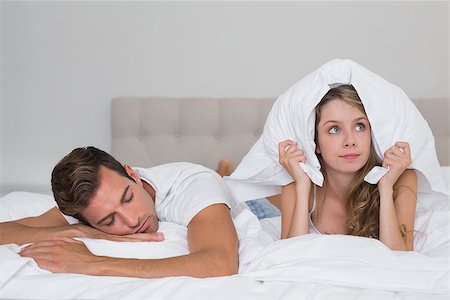 Angry young woman holding pillow besides a sleeping man in bed at home Stock Photo - Budget Royalty-Free & Subscription, Code: 400-07343528