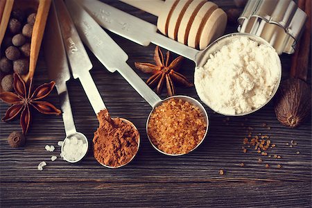 simsearch:400-05721521,k - Food ingredients and kitchen utensils for cooking on a wooden board. Measuring spoons with cocoa, flour and brown sugar and spices. Toned photo. Stock Photo - Budget Royalty-Free & Subscription, Code: 400-07414850
