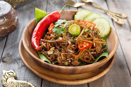 simsearch:400-07418409,k - Mi goreng or mee goreng mamak, Indonesian and Malaysian cuisine, spicy fried noodles with wooden dining table setting. Fresh hot with steamed smoke. Stock Photo - Budget Royalty-Free & Subscription, Code: 400-07418420