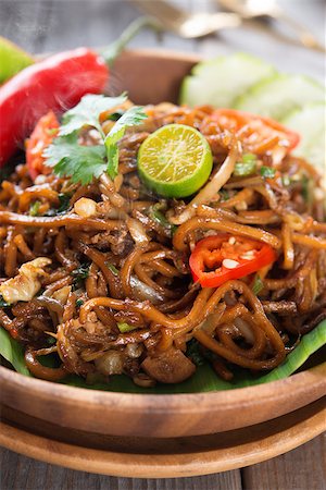 simsearch:400-07418409,k - Indonesian and Malaysian cuisine, mi goreng or mee goreng mamak,  spicy fried noodles with wooden dining table setting. Fresh hot with steamed smoke. Stock Photo - Budget Royalty-Free & Subscription, Code: 400-07418421