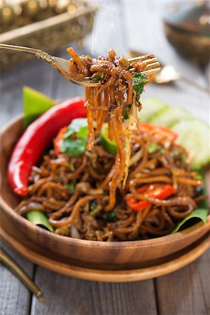 simsearch:400-07418409,k - Indonesian and Malaysian cuisine, spicy fried noodles, mi goreng or mee goreng mamak with wooden dining table setting. Fresh hot with steamed smoke. Stock Photo - Budget Royalty-Free & Subscription, Code: 400-07418422
