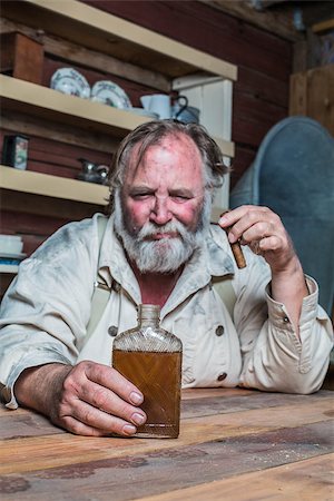 Unhappy Drunk Cigar Smoking Western Man Looks Towards His Drink as he Sits at Table Stock Photo - Budget Royalty-Free & Subscription, Code: 400-07410142
