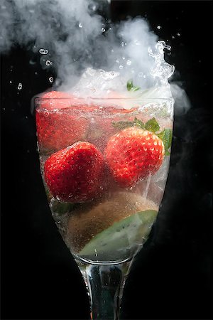 Cocktail of fruit in a glass exploding with steam and smoke, with water movement frozen, all on a black background Stock Photo - Budget Royalty-Free & Subscription, Code: 400-07446247