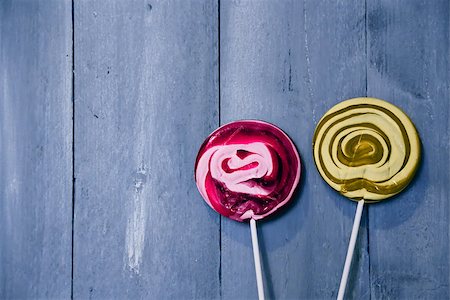 red stick candy - Photo of pink and yellow lollipops on wooden background Photographie de stock - Aubaine LD & Abonnement, Code: 400-07449438