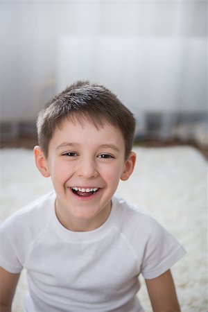 face to internet technology - Smiling boy indoor. Sitting on the floor Stock Photo - Budget Royalty-Free & Subscription, Code: 400-07449492