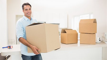 simsearch:400-07930718,k - Portrait of a smiling man carrying boxes in a new house Stock Photo - Budget Royalty-Free & Subscription, Code: 400-07467762