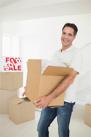simsearch:400-07930718,k - Portrait of a cheerful man carrying boxes in a new house Stock Photo - Budget Royalty-Free & Subscription, Code: 400-07467872