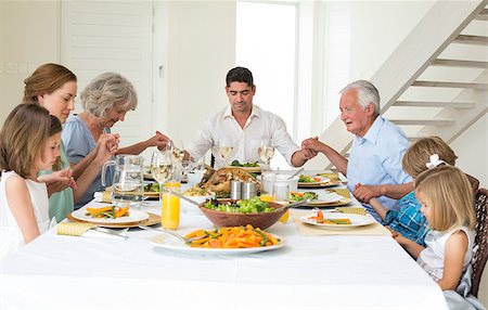 Multigeneration family praying together before meal at dining table Stock Photo - Budget Royalty-Free & Subscription, Code: 400-07468437