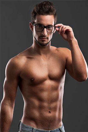 Shirtless male model posing with glasses over a gray background Foto de stock - Super Valor sin royalties y Suscripción, Código: 400-07462874