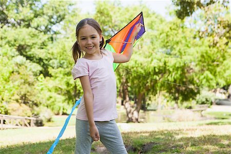 Portrait of a happy young girl holding kite at the park Stock Photo - Budget Royalty-Free & Subscription, Code: 400-07474936