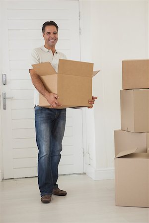 simsearch:400-07930718,k - Portrait of a smiling man carrying boxes in new house Stock Photo - Budget Royalty-Free & Subscription, Code: 400-07475269