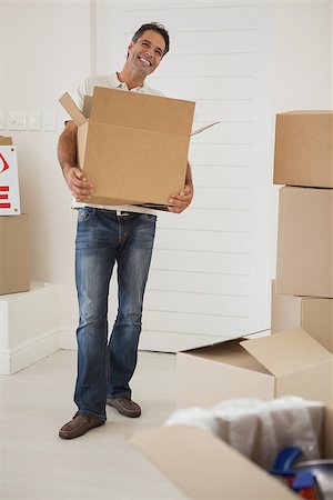 simsearch:400-07930718,k - Full length portrait of a smiling man carrying boxes in new house Stock Photo - Budget Royalty-Free & Subscription, Code: 400-07475271