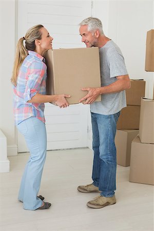 simsearch:400-07927836,k - Happy couple carrying cardboard moving boxes in new home Stock Photo - Budget Royalty-Free & Subscription, Code: 400-07475975