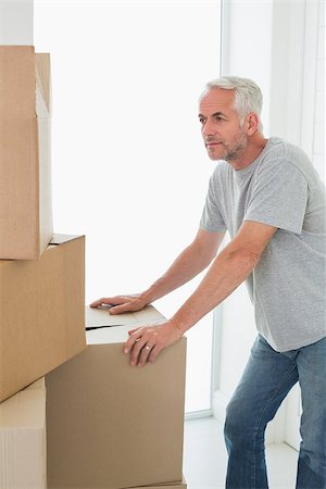 simsearch:400-07927836,k - Thoughtful man looking at cardboard moving boxes in new home Stock Photo - Budget Royalty-Free & Subscription, Code: 400-07475971