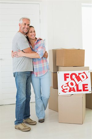 simsearch:400-07927836,k - Happy couple standing and hugging beside sold sign in their new home Stock Photo - Budget Royalty-Free & Subscription, Code: 400-07475984