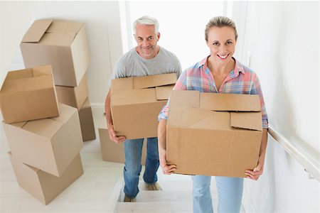 simsearch:400-07927836,k - Happy couple carrying cardboard moving boxes in their new home Stock Photo - Budget Royalty-Free & Subscription, Code: 400-07475981