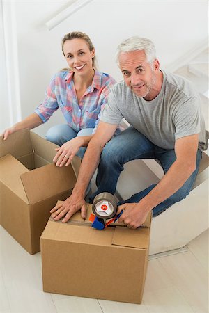 simsearch:400-07927836,k - Happy couple sealing cardboard moving boxes in their old home Stock Photo - Budget Royalty-Free & Subscription, Code: 400-07475998