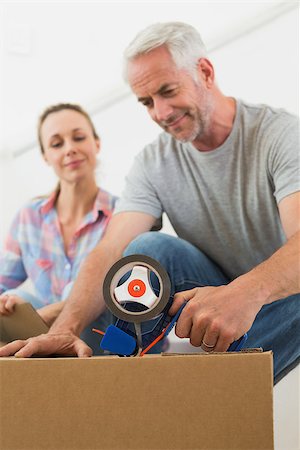 simsearch:400-07927836,k - Happy couple sealing cardboard moving boxes in their old home Stock Photo - Budget Royalty-Free & Subscription, Code: 400-07475999