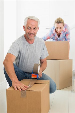 simsearch:400-07927836,k - Happy couple sealing cardboard moving boxes in their old home Stock Photo - Budget Royalty-Free & Subscription, Code: 400-07476005