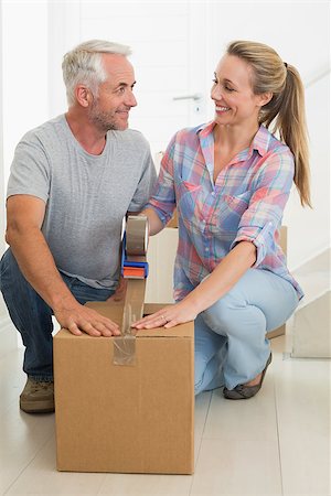 simsearch:400-07927836,k - Happy couple sealing cardboard moving boxes in their old home Stock Photo - Budget Royalty-Free & Subscription, Code: 400-07476006