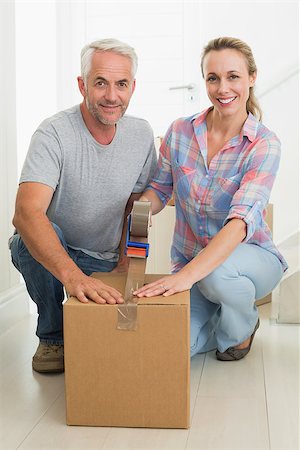 simsearch:400-07927836,k - Happy couple sealing cardboard moving boxes in their old home Stock Photo - Budget Royalty-Free & Subscription, Code: 400-07476007