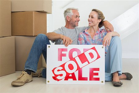 simsearch:400-07927836,k - Happy couple sitting on floor with sold sign in their new home Stock Photo - Budget Royalty-Free & Subscription, Code: 400-07476008