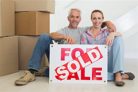 simsearch:400-07927836,k - Happy couple sitting on floor with sold sign in their new home Stock Photo - Budget Royalty-Free & Subscription, Code: 400-07476009