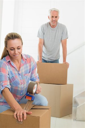simsearch:400-07927836,k - Happy couple sealing cardboard moving boxes in their old home Stock Photo - Budget Royalty-Free & Subscription, Code: 400-07476001