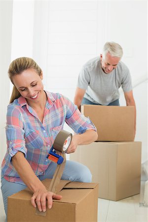 simsearch:400-07927836,k - Happy couple sealing cardboard moving boxes in their old home Stock Photo - Budget Royalty-Free & Subscription, Code: 400-07476002