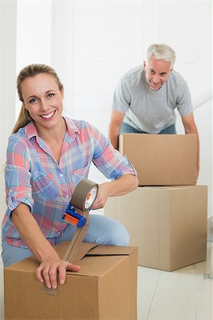 simsearch:400-07927836,k - Happy couple sealing cardboard moving boxes in their old home Stock Photo - Budget Royalty-Free & Subscription, Code: 400-07476003
