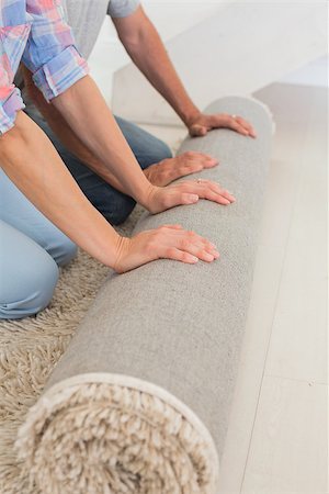 simsearch:400-07927836,k - Couple rolling out new rug in their new home Stock Photo - Budget Royalty-Free & Subscription, Code: 400-07476018
