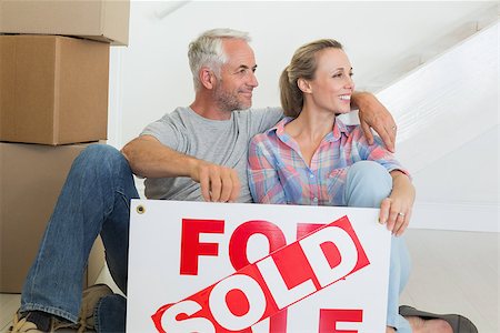 simsearch:400-07927836,k - Happy couple sitting on floor with sold sign in their new home Stock Photo - Budget Royalty-Free & Subscription, Code: 400-07476010