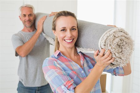 simsearch:400-07927836,k - Happy couple carrying a rolled up rug together in their new home Stock Photo - Budget Royalty-Free & Subscription, Code: 400-07476021