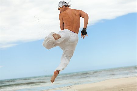 simsearch:400-04347301,k - man is jumping sport karate martial arts fight kick jump beach summertime Photographie de stock - Aubaine LD & Abonnement, Code: 400-07478088