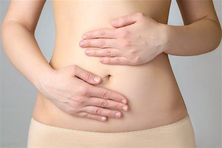 pregnancy nude - Closeup of a young woman's abdomen and hands Photographie de stock - Aubaine LD & Abonnement, Code: 400-07479941