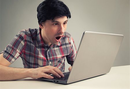 face to internet technology - shocking man reading message on laptop computer Stock Photo - Budget Royalty-Free & Subscription, Code: 400-07472868