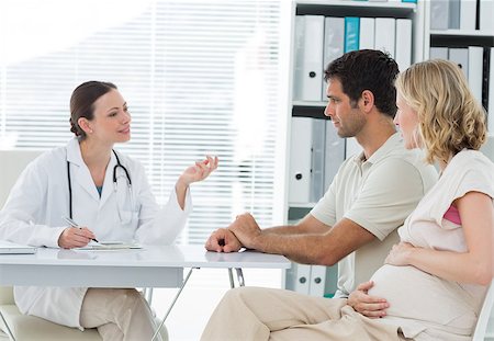 Female gynaecologist discussing with expectant couple in clinic Photographie de stock - Aubaine LD & Abonnement, Code: 400-07473279