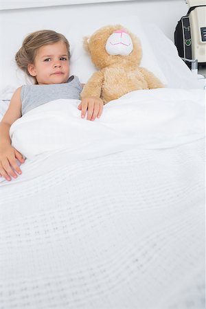 Portrait of cute girl with teddy bear lying in hospital bed Stock Photo - Budget Royalty-Free & Subscription, Code: 400-07473362