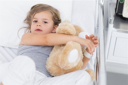 High angle portrait of cute girl hugging teddy bear while lying in hospital bed Stock Photo - Budget Royalty-Free & Subscription, Code: 400-07473391