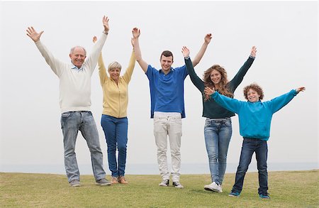 simsearch:400-07426233,k - Happy family standing on lawn, hands raised Stock Photo - Budget Royalty-Free & Subscription, Code: 400-07480716
