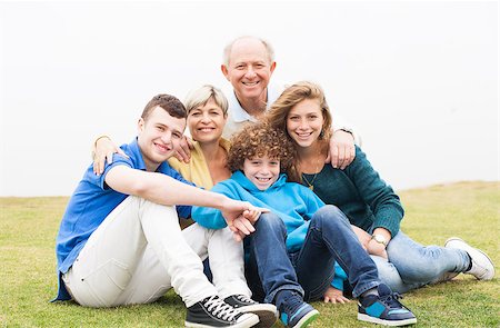 simsearch:400-07426233,k - Attractive happy, smiling family sitting on the grass Stock Photo - Budget Royalty-Free & Subscription, Code: 400-07480728