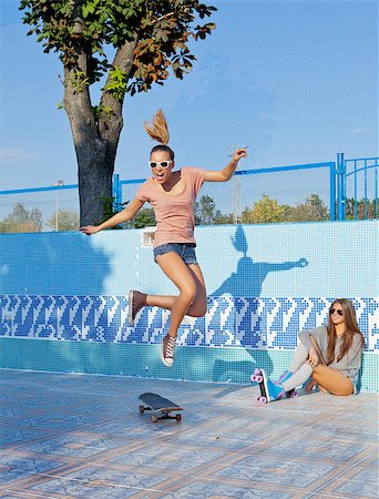 roller skate - two beautiful young girls in an empty pool, one watches the other jumping over the skateboard Foto de stock - Super Valor sin royalties y Suscripción, Código: 400-07481311